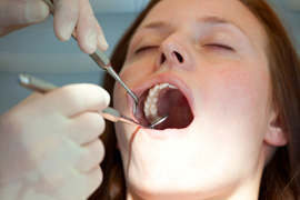 Woman having her teeth worked on with dental tools